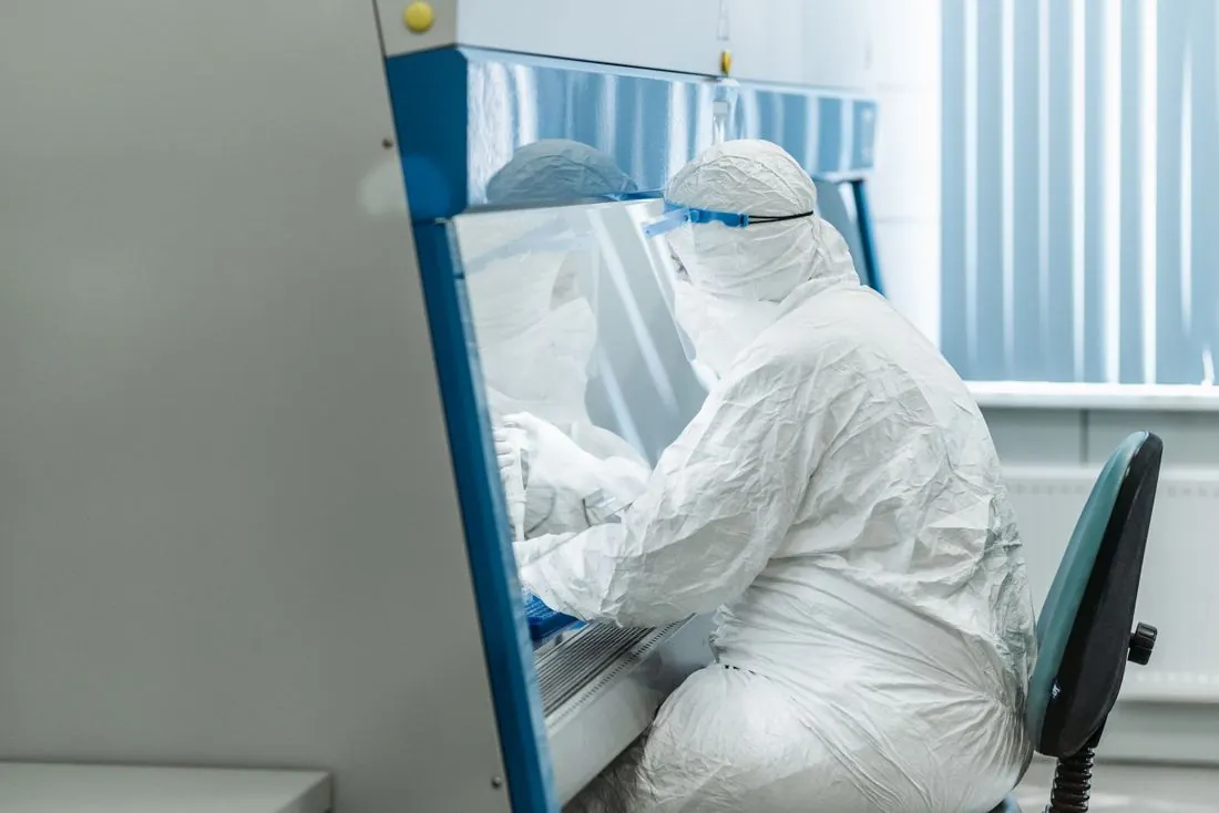 Technicien en salle blanche sous poste de sécurité microbiologique